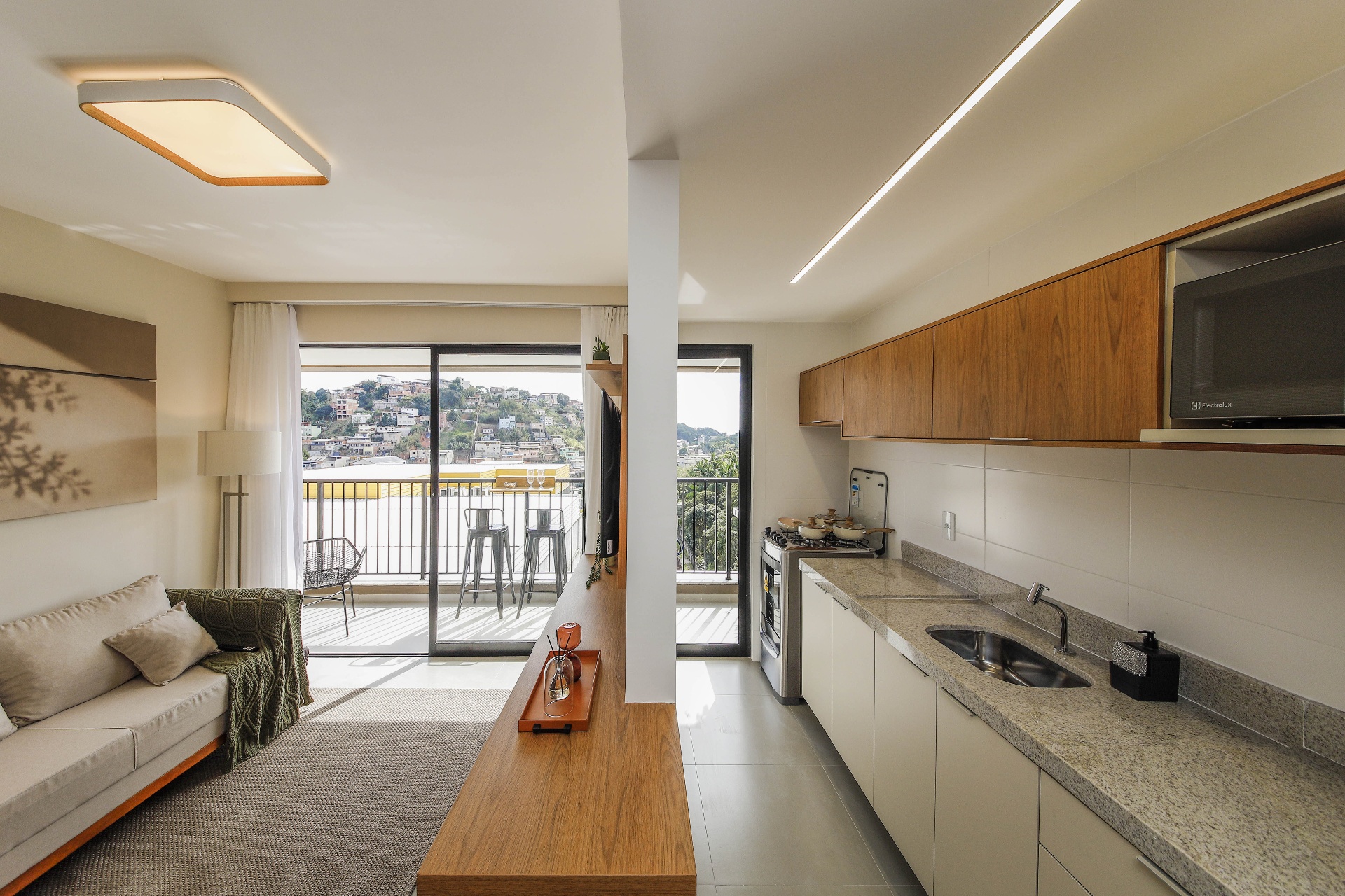 Sala estendida com cozinha americana e vista do bairro São Pedro